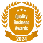 A shield with a laurel wreath and a ribbon that says quality business awards 2024.