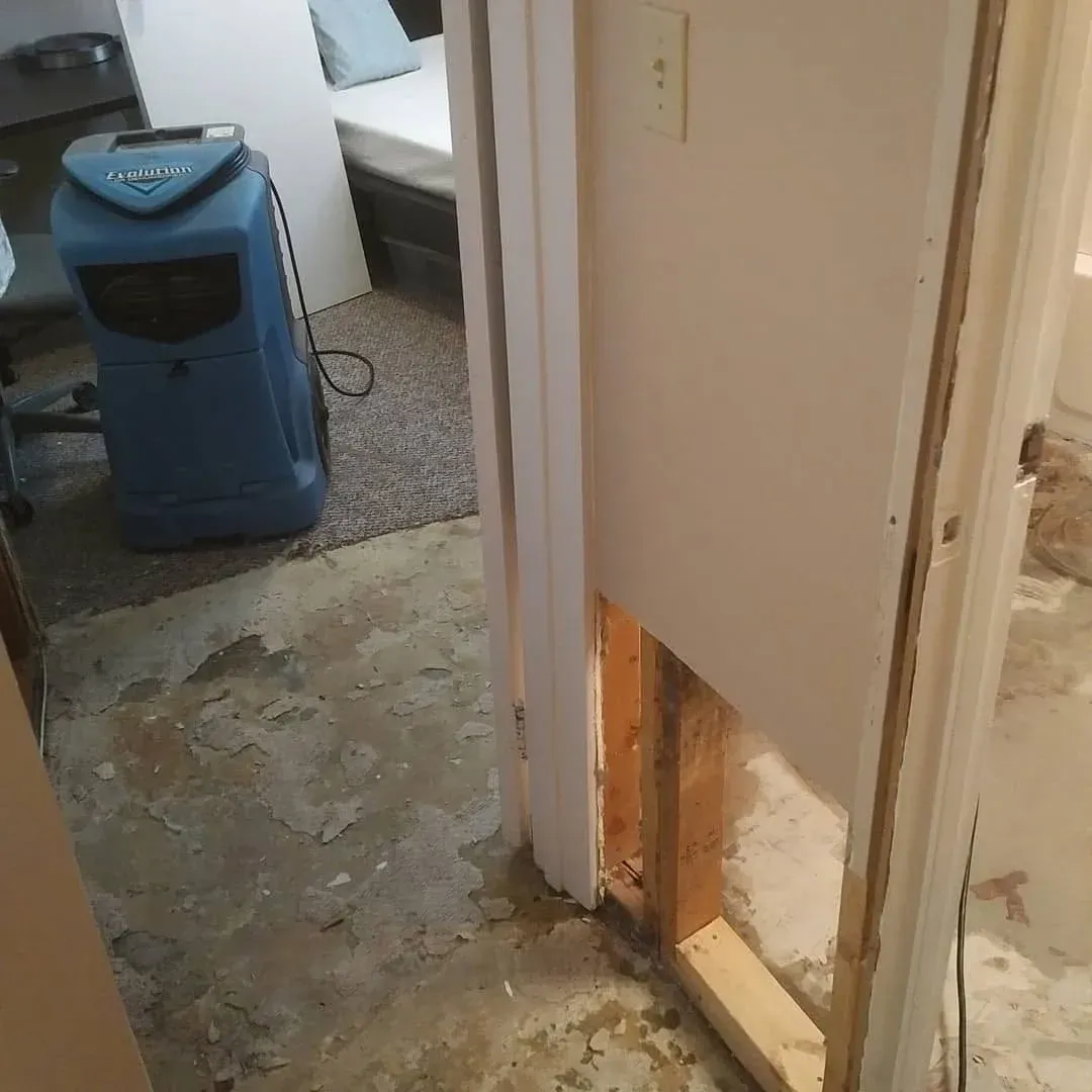 Water-damaged flooring and drywall being dried with commercial restoration equipment in Saskatoon